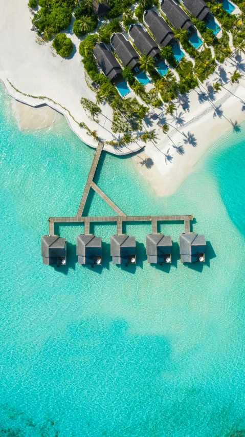 an aerial view of an ocean resort with beach huts