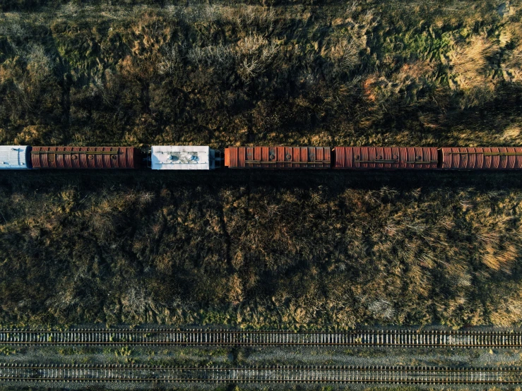 an aerial po of a train going past a wooded area