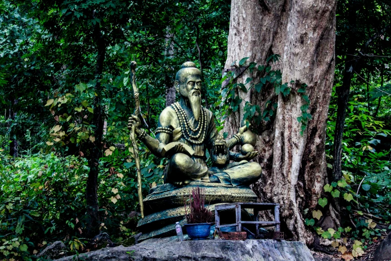 a buddha statue is sitting in a park