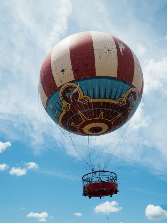 a red and white striped  air balloon next to a round device