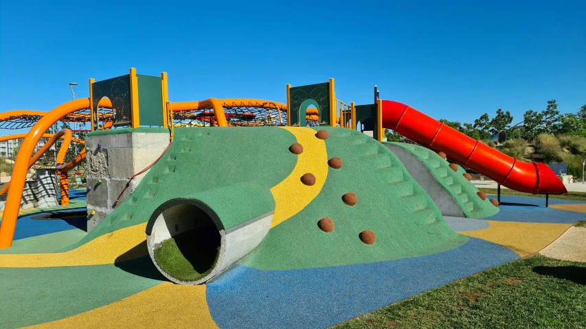 a large colorful playground has lots of play equipment
