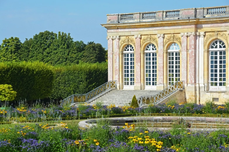 an old building surrounded by a field of flowers