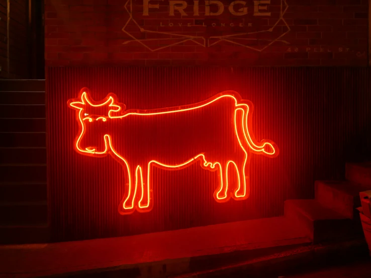 the neon sign shows a cow with long horns on it's head