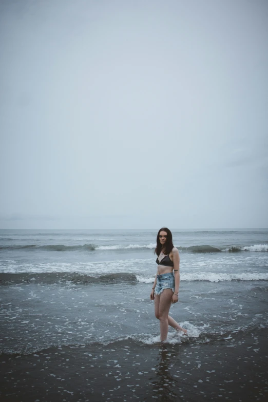 a woman walking on the beach with a kite in her hands