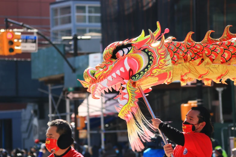 a group of people and a dragon balloon on a city street