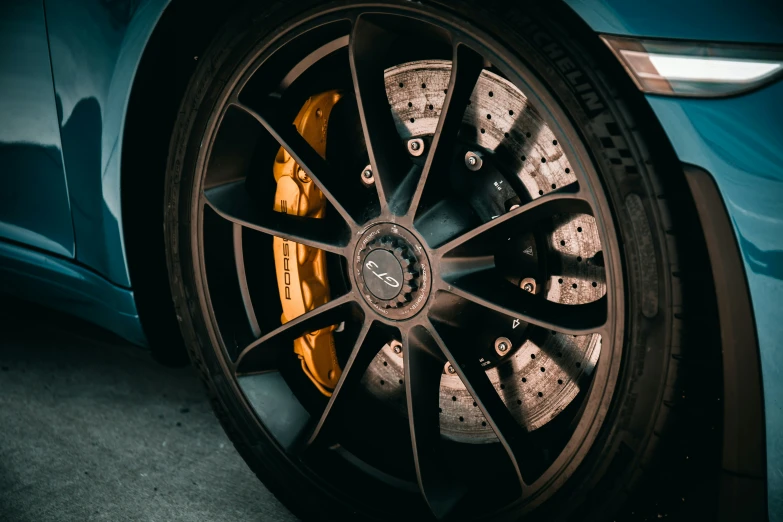 the rim on a blue sports car in a dark room