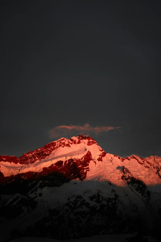 red lit mountain peaks under dark sky