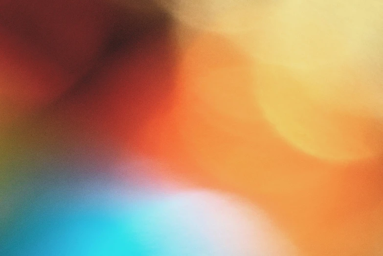 a close up of an orange blue and green blurry background