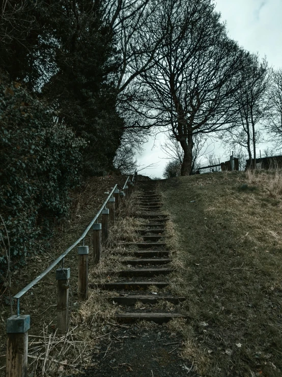 an old, worn set of stairs lead up a grassy hill