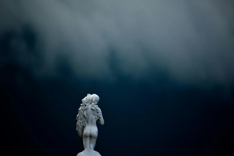 a statue with an umbrella on it is shown against a cloudy sky