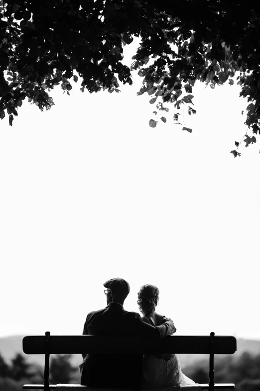 a black and white image of the couple on a bench