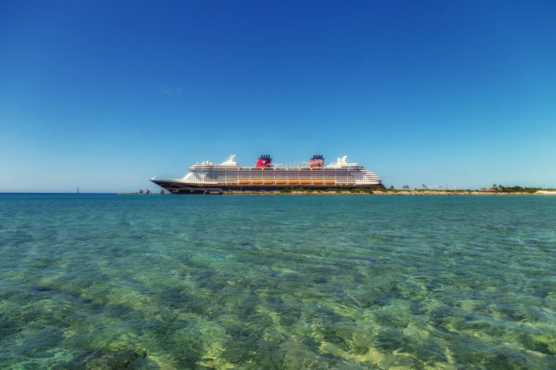 a cruise ship in the ocean with clear water