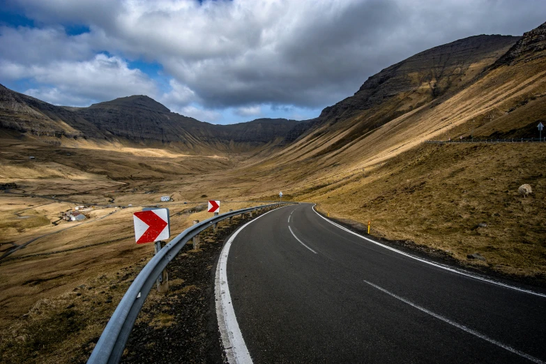 a highway going through some big hills next to mountains