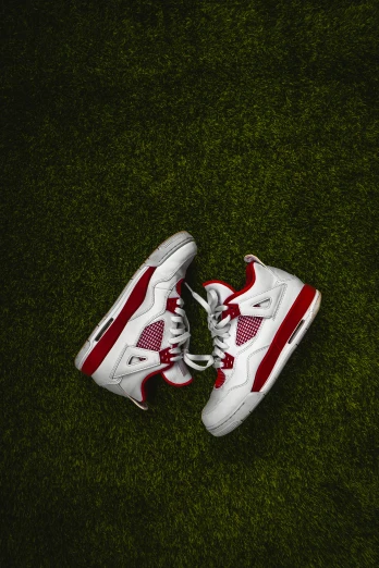 white nike sneakers with red accents are placed on a grassy field