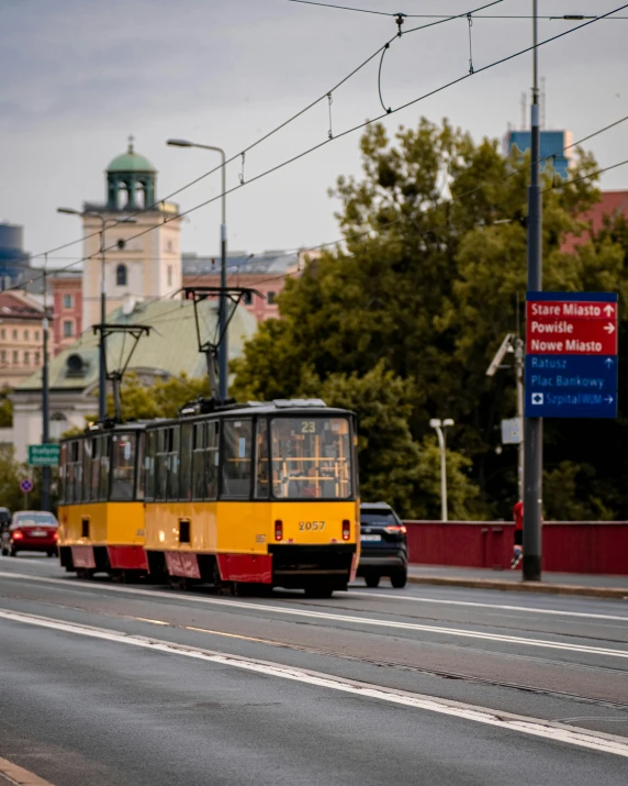 a small yellow and red tram on the street