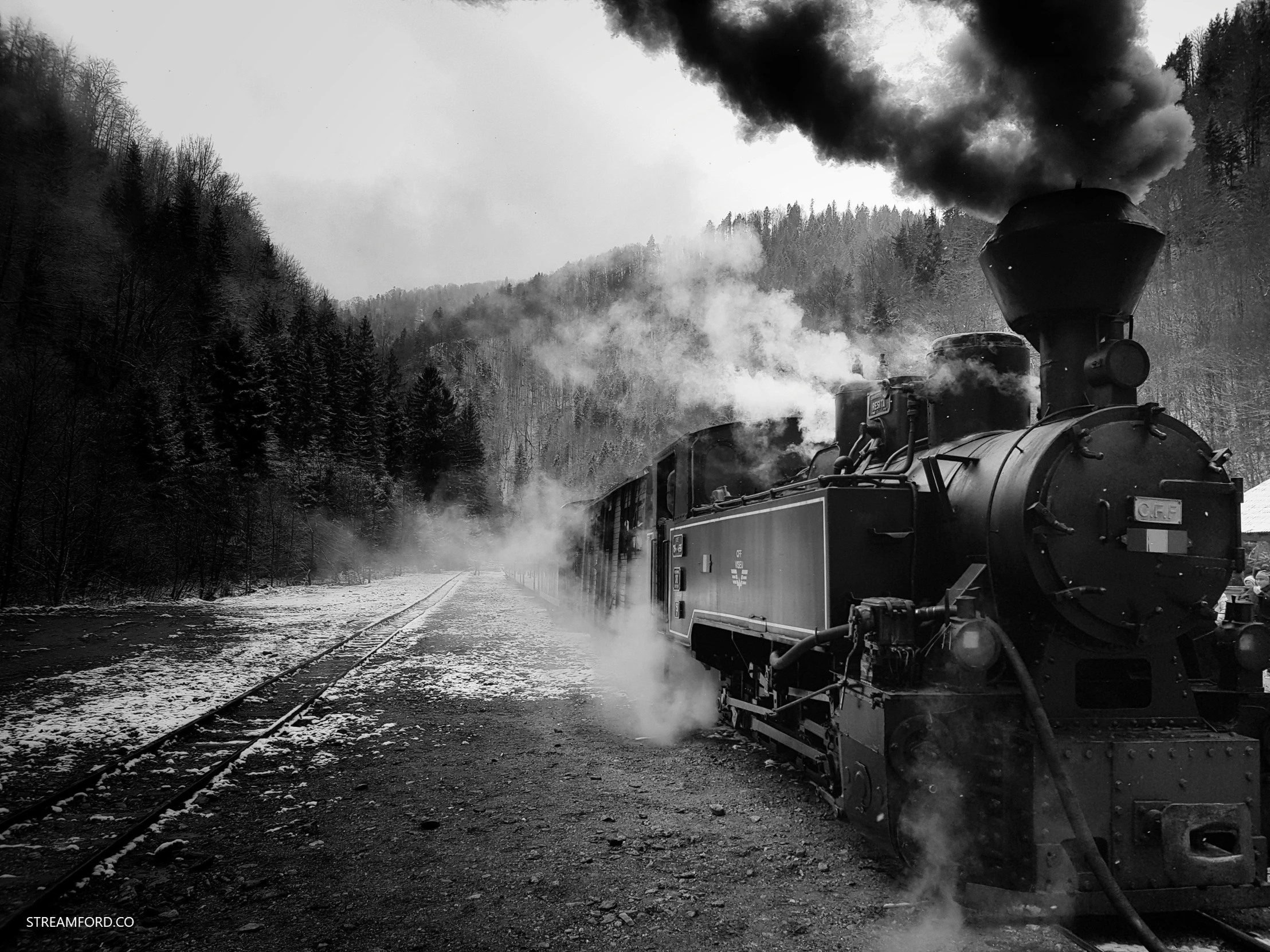 black and white image of steam train on track