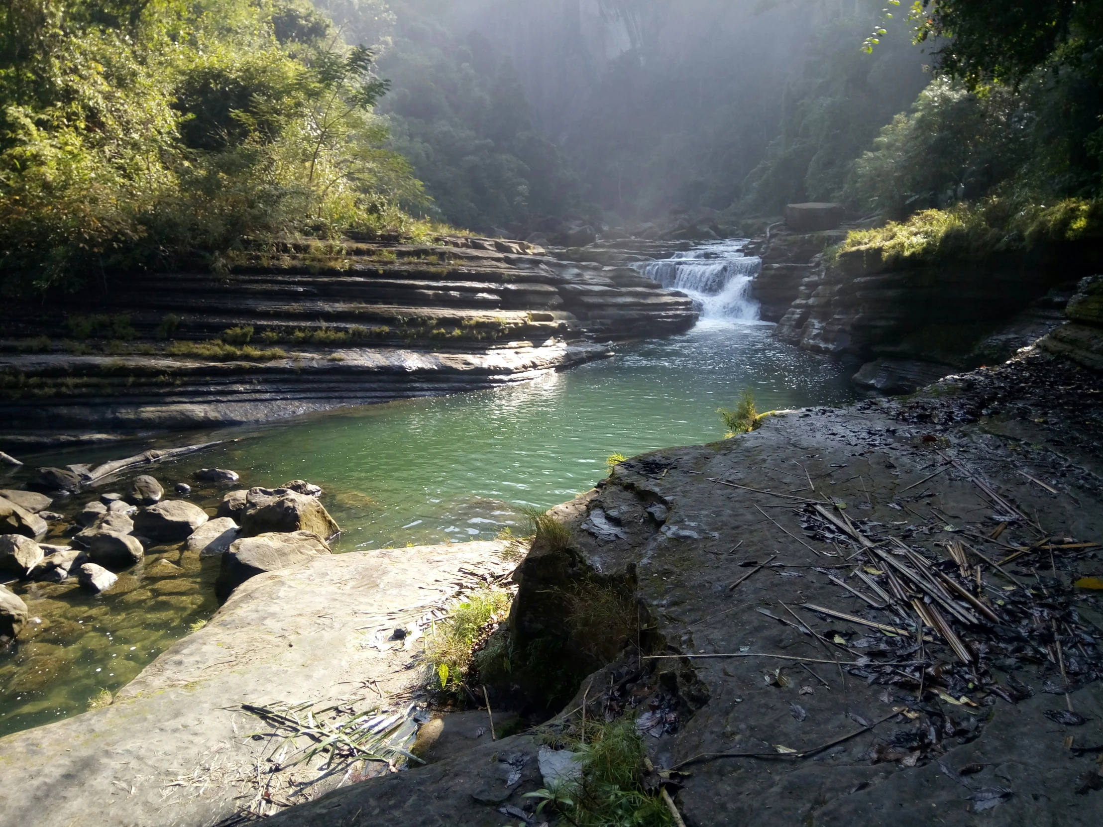 a river runs into the water and has steps to a waterfall