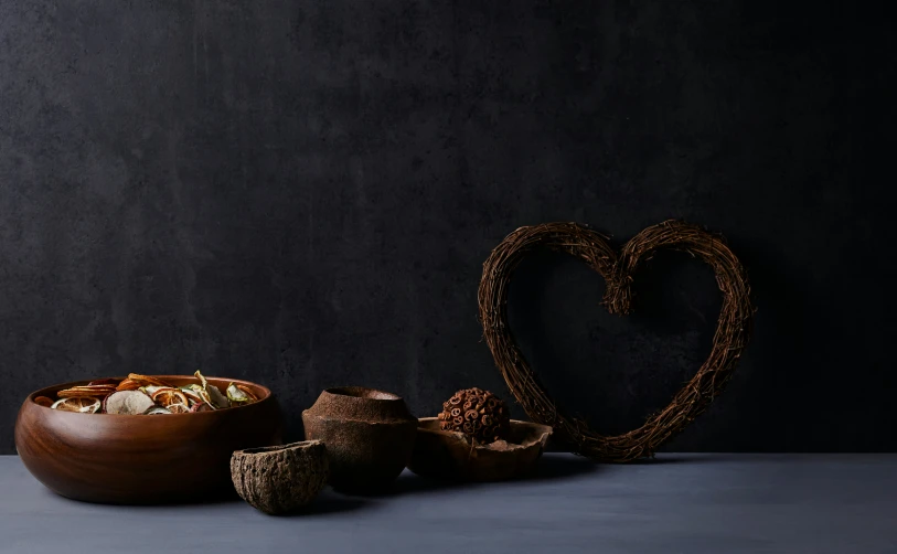 a bowl of nuts sits beside a bowl with hearts