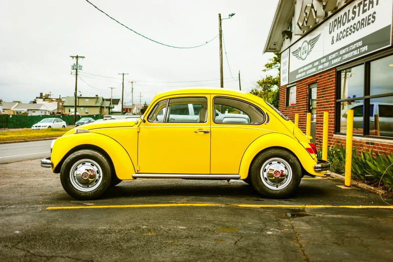 the bright yellow vw bug sits outside the building