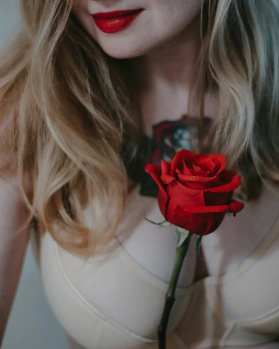 a woman wearing red lipstick and a flower in her hair