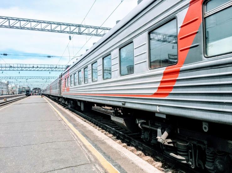 an old gray passenger train is stopped at the station