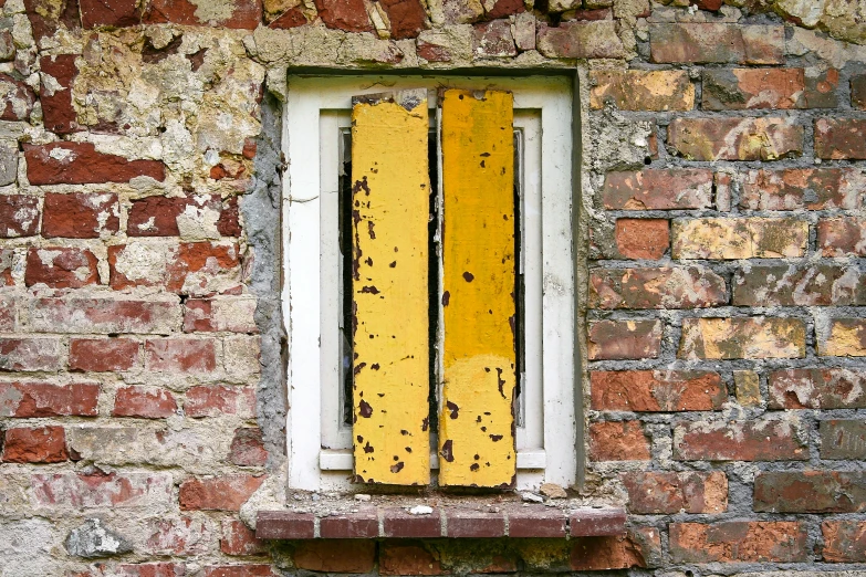 an old brick building with yellow paint and a window