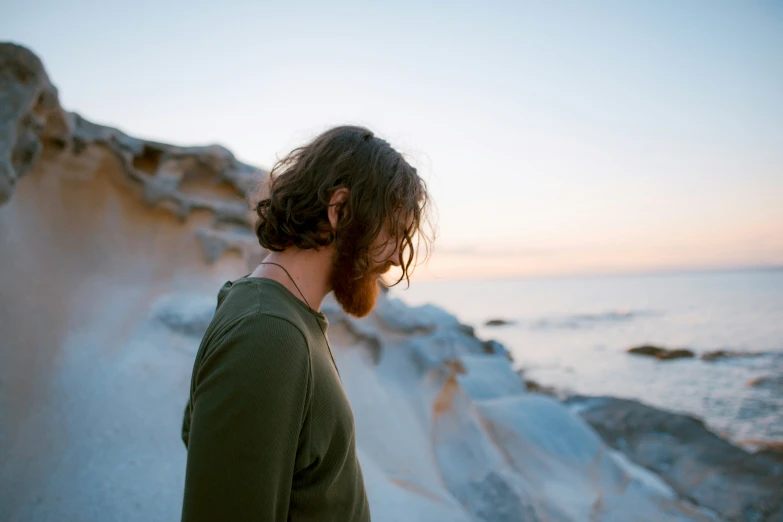 a person standing in front of the ocean at sunset