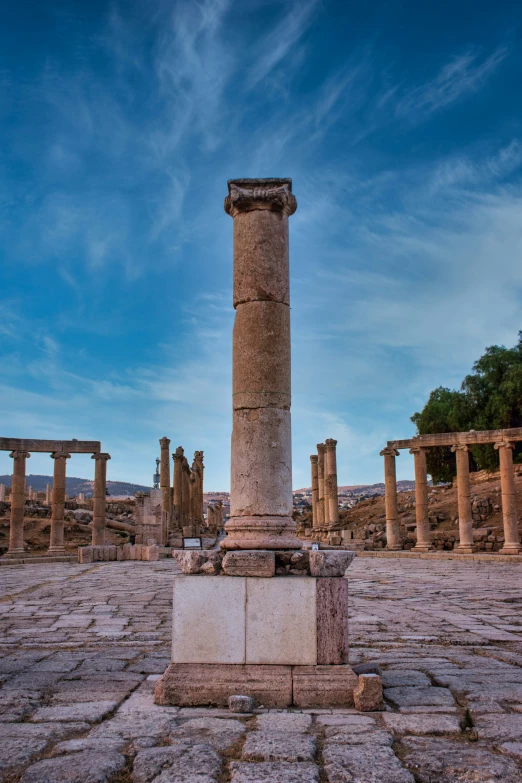 an old ruins that have a tower and pillars in it