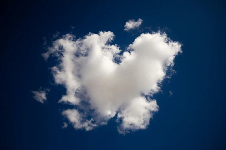 a heart shaped cloud floating in a blue sky