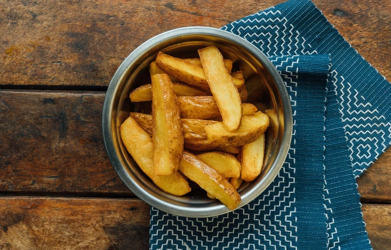 the bowl contains some fried french fries on the side