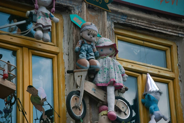 two small stuffed bears on a wooden building with decorations on the side