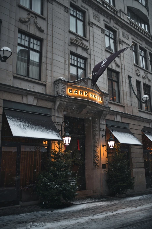 the front entrance of a tall building with an umbrella on top