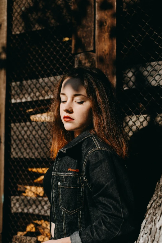 a girl standing near a fence with long hair