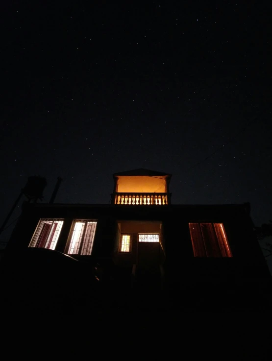 the night sky is lit up with two windows and a balcony