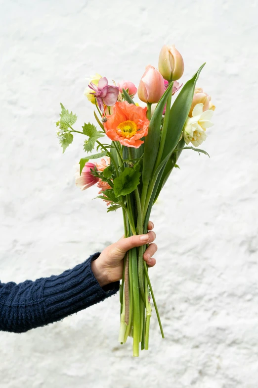 a woman holding a bunch of flowers in her hand