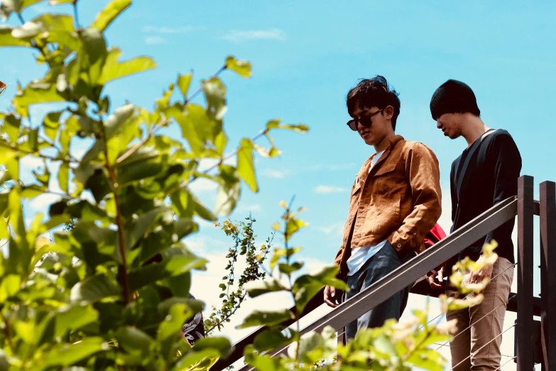 two young people are standing on the railings