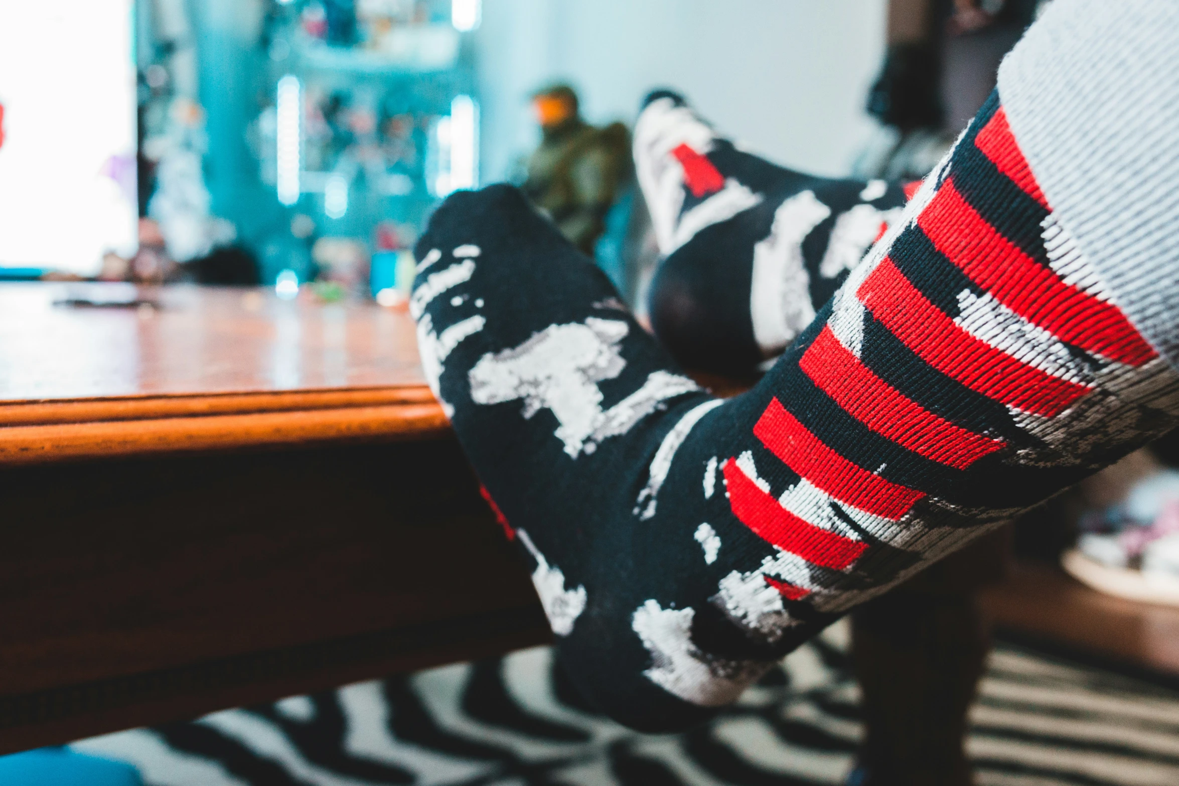 someone's legs in striped socks near table