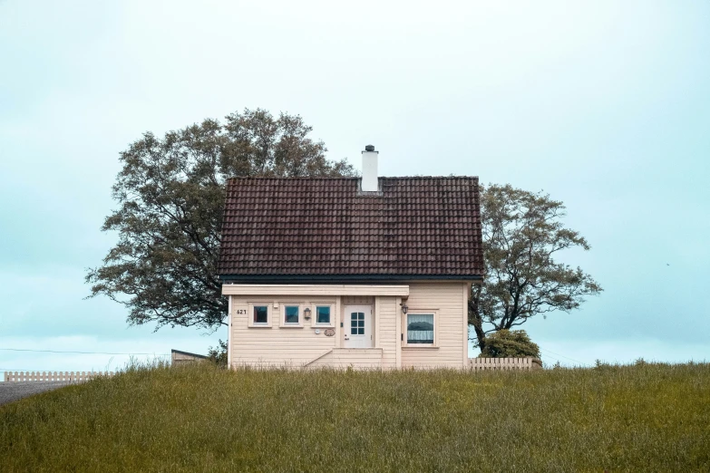 a small white house in a field next to trees