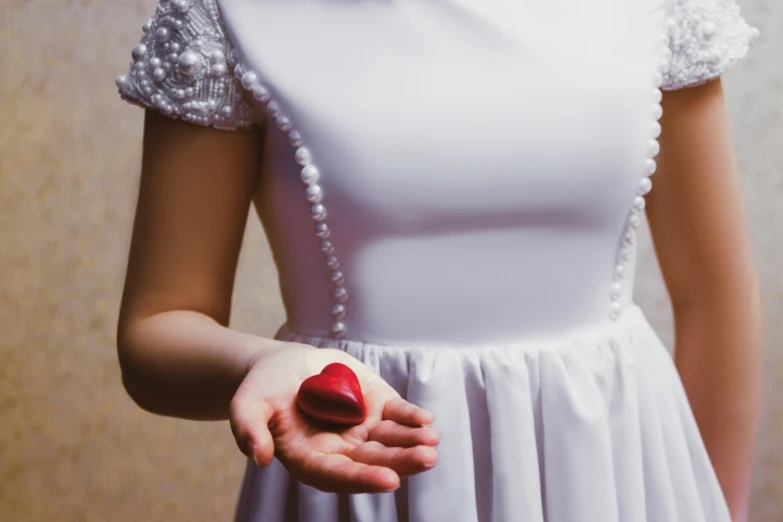 a woman in white dress holding an apple