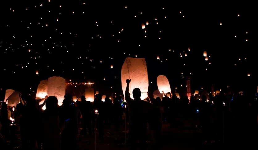 a crowd of people standing around paper lanterns