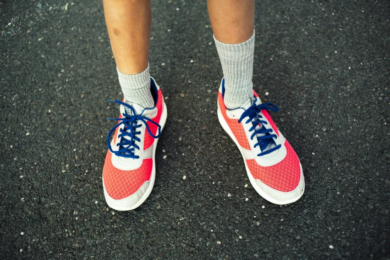 a close up po of someone wearing red and blue tennis shoes
