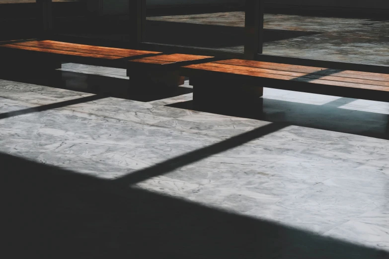 the shadow from a mirror shows some benches with no back