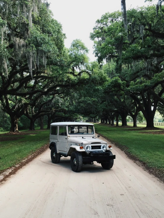 a large white suv on the dirt road