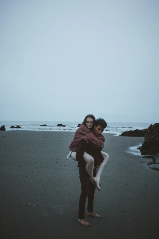 couple in black and white hugging each other on beach