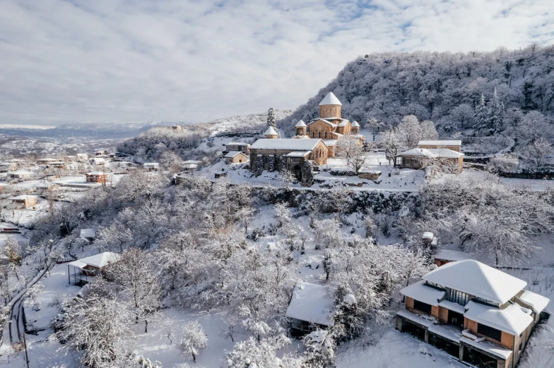 a mountain top covered in snow with a town in the distance