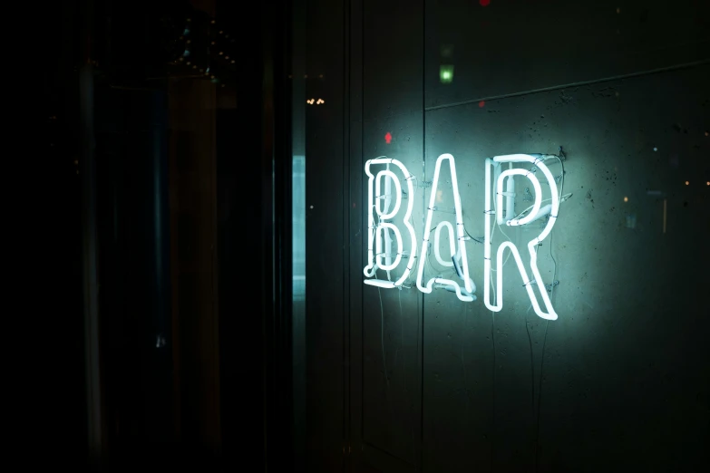 an illuminated sign hanging in a dark room