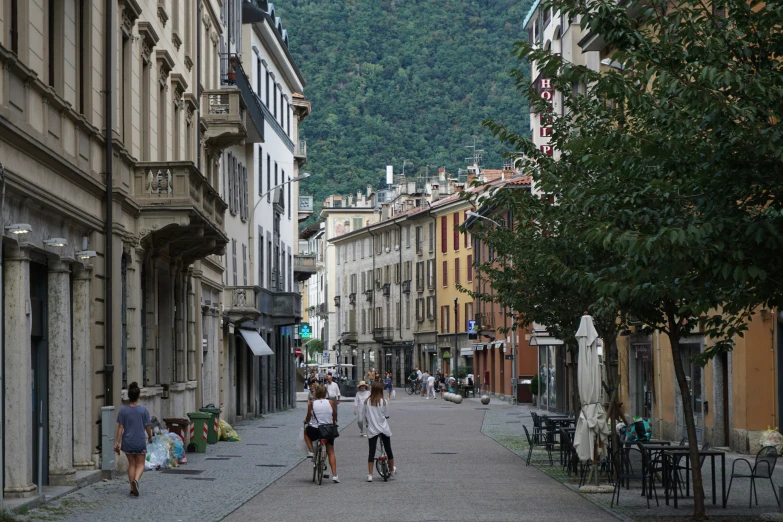 the young people are riding their bicycles down the narrow city street