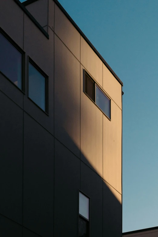 a tall building with lots of windows in front of a blue sky