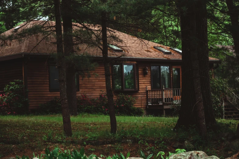 a wooden cabin is surrounded by trees and rocks