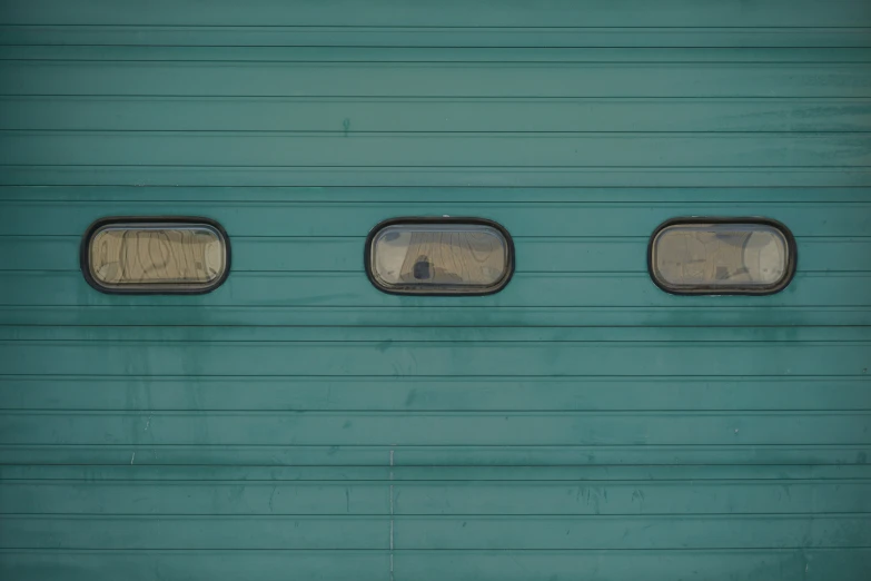 the reflection of people walking by in the windows of a train